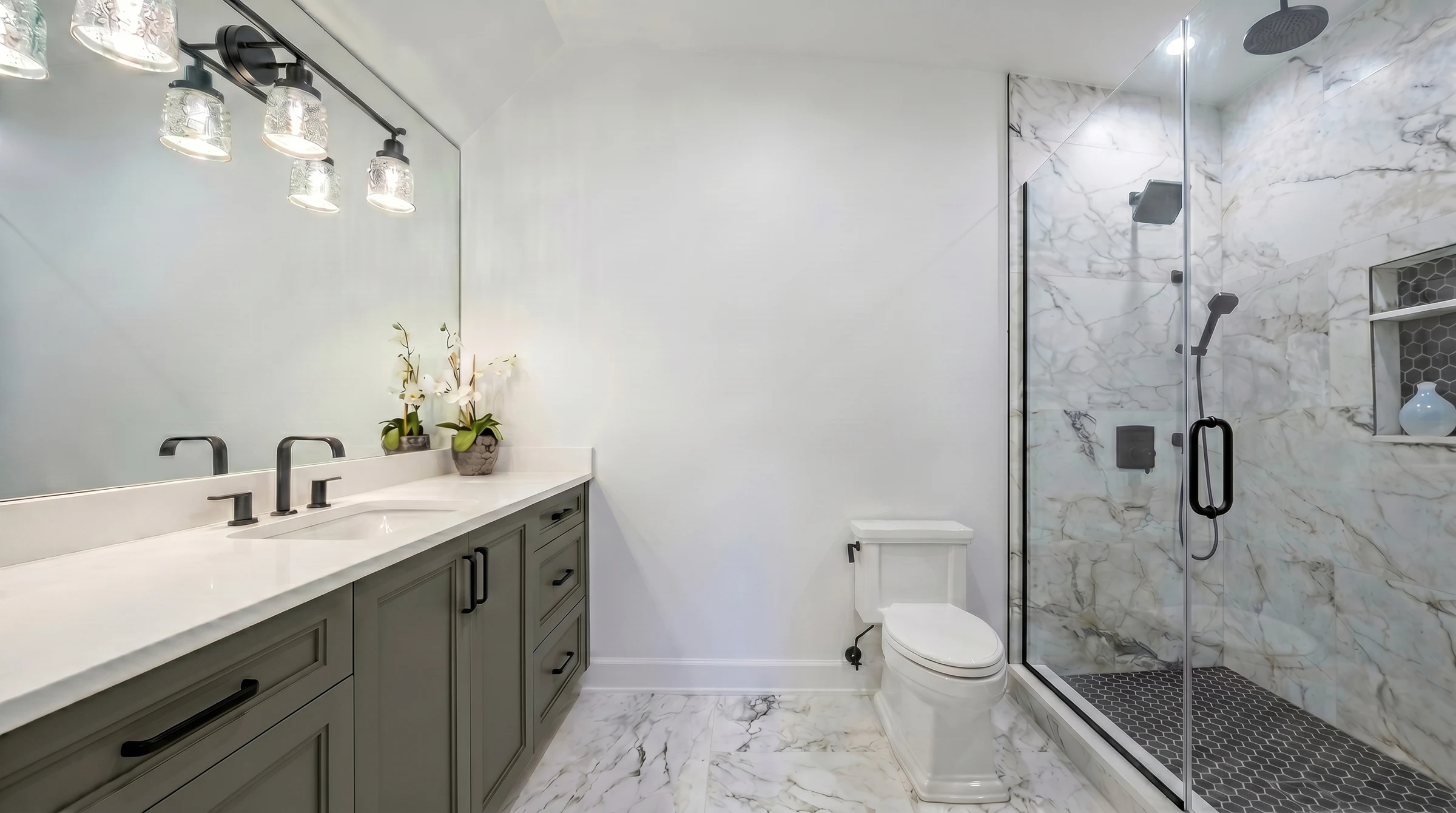Narrow bath in soft grey with black fixtures and a marble shower
