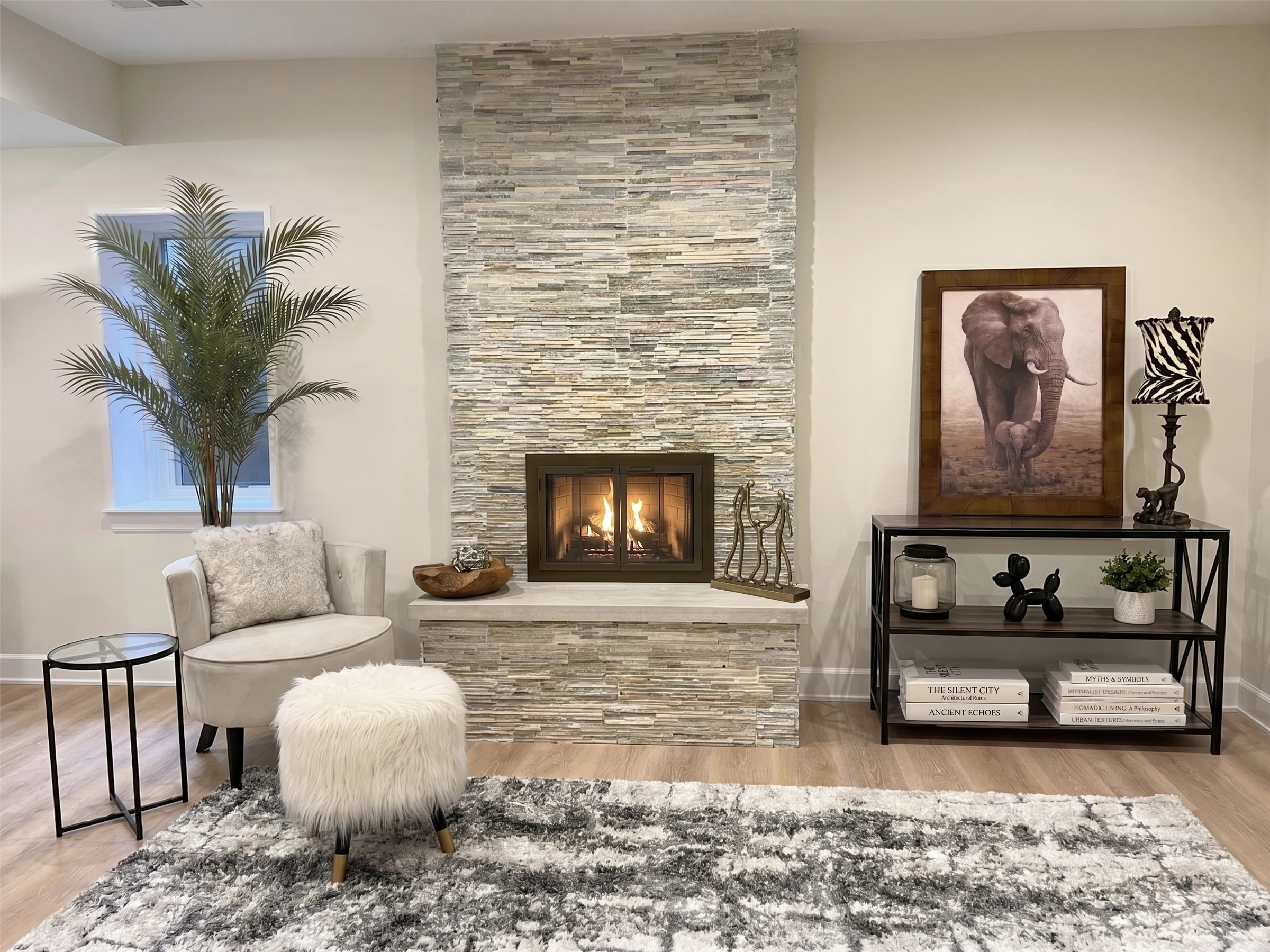 Sitting room with a stone fireplace, a soft armchair and framed art