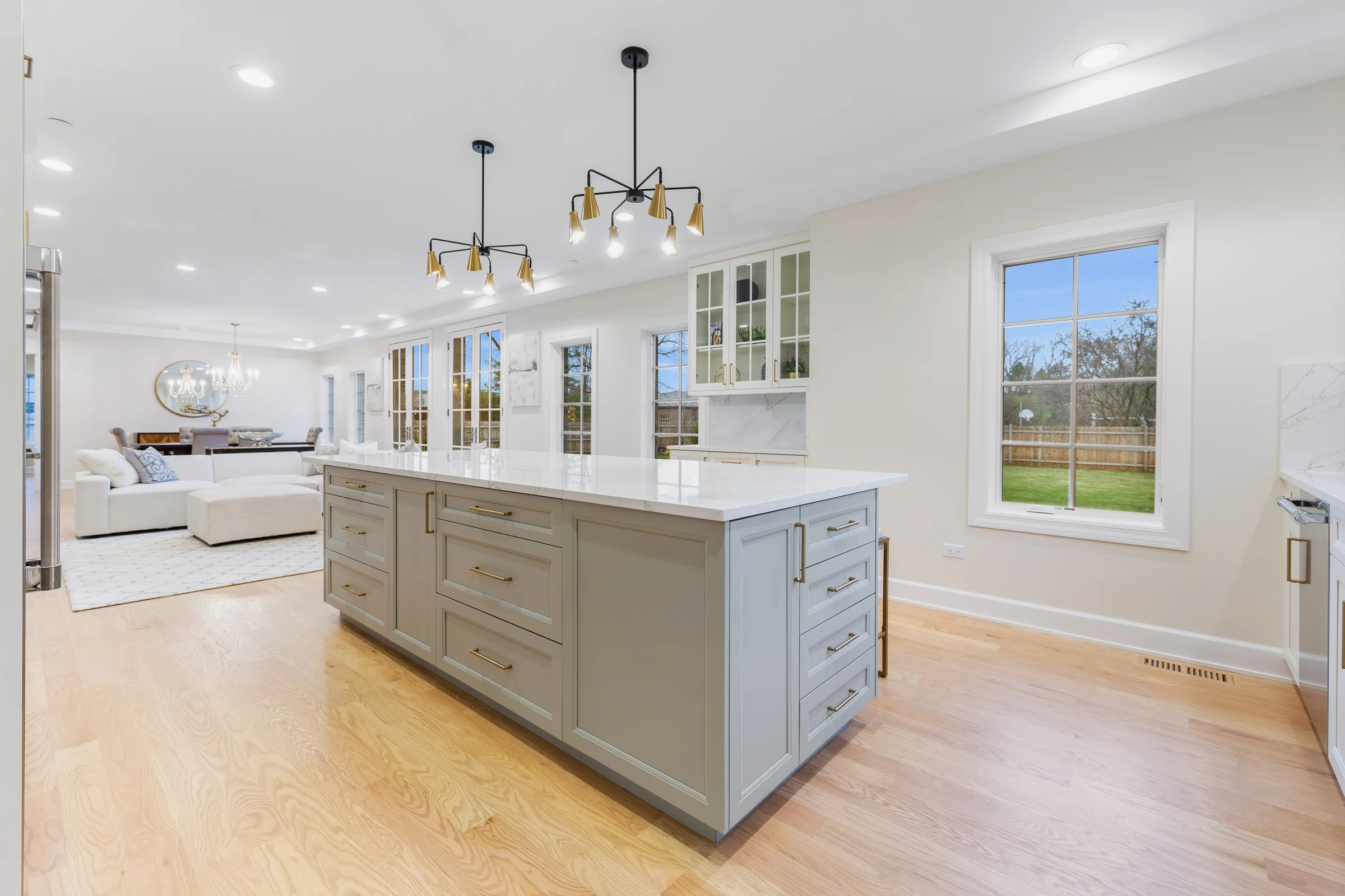Kitchen island in soft grey, opening through to the living room beyond