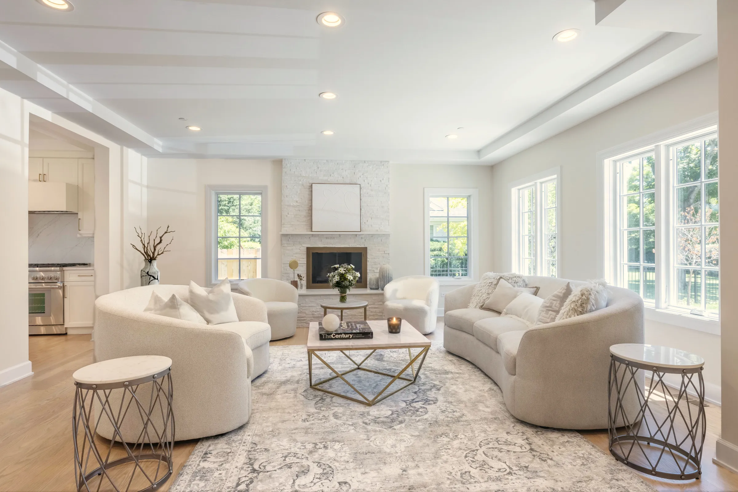 Bright white living room with large windows and curved sofas