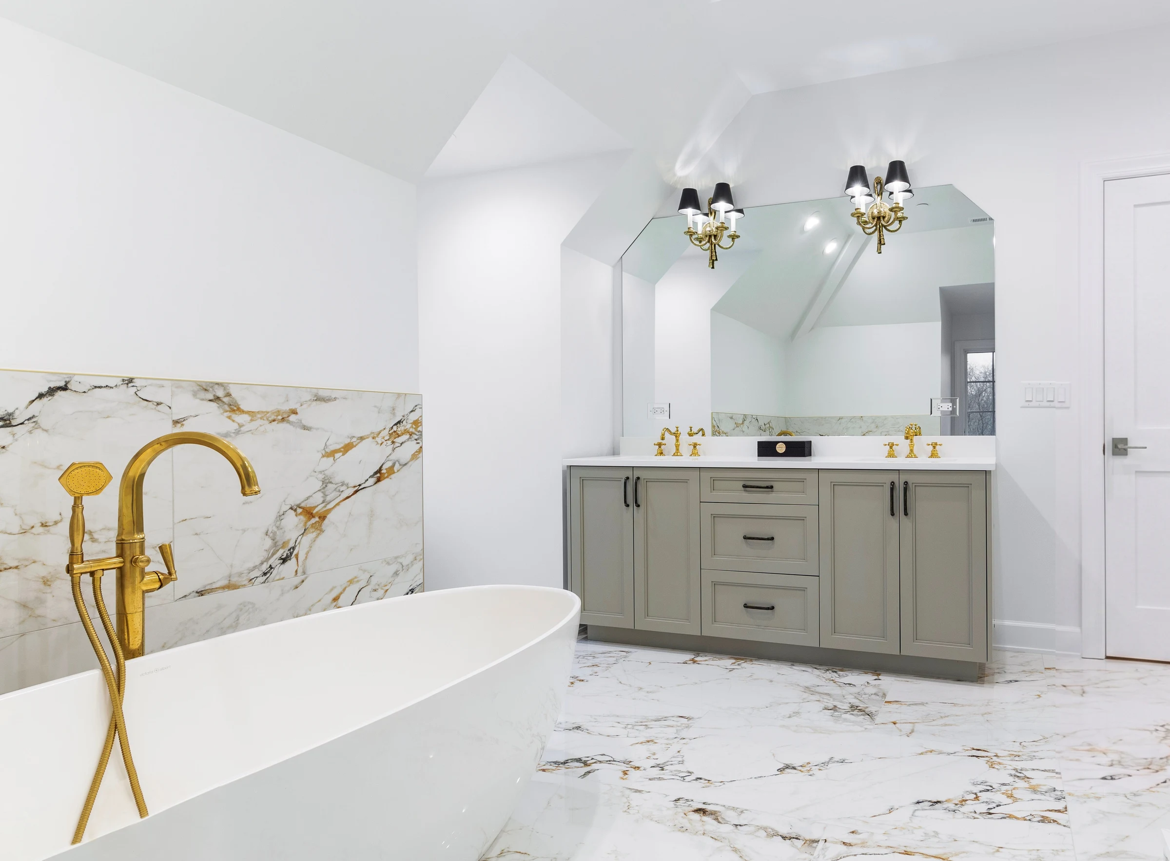 Principal bath with a freestanding tub, book-matched marble and a grey vanity